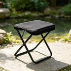 Taburete plegable compacto para actividades al aire libre.